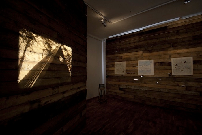 Detail from Acts of Refusal in Tartu Artists Association House, 2011. Andreas Bunte, May the Circle Remain Unbroken, 2005, 16 mm film projection, 2 wooden walls, radio, 6 maps, 1 print.