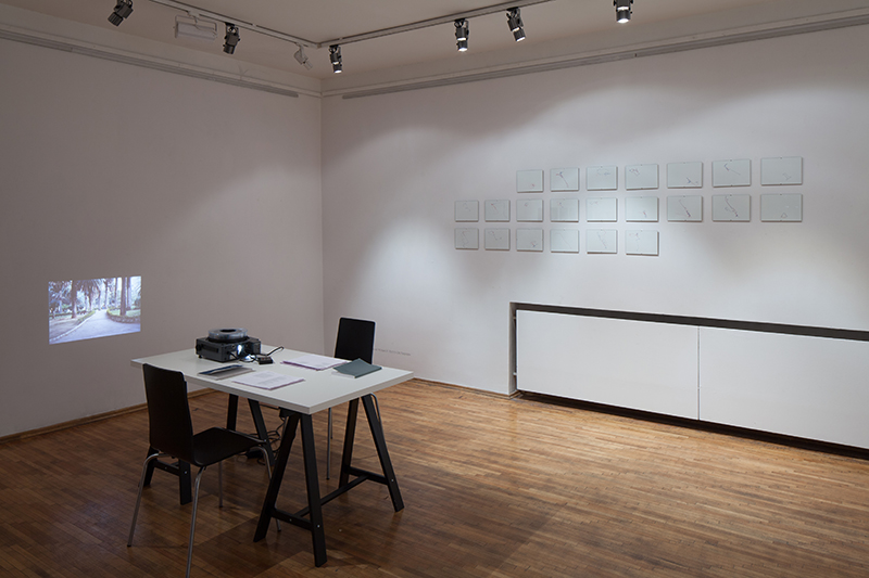 Petra Köhle & Nicolas Vermot Petit-Outhenin - There where I should have been yesterday. I am here today, 2006-12. Simultaneous lecture. Performative setting with slide projection, texts, prints, table, chairs